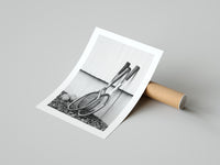 Monochrome tennis rackets poster partly unrolled beside a cardboard shipping tube on a gray surface