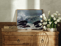 Crashing waves on rocky coast print in an oak frame on a farmhouse dresser beside white tulips
