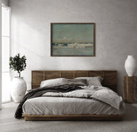 Ocean waves breaking on shore print in a dark wood frame above a rattan bed on a plaster wall
