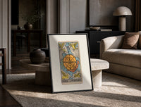 Wheel of Fortune tarot card print in a black frame leaning on a travertine table in a sunlit lounge