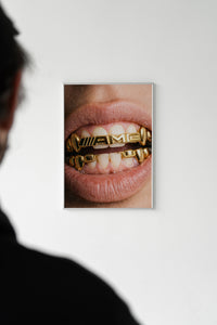 White-framed AMG grillz wall art on a white wall with a silhouetted person standing in the foreground