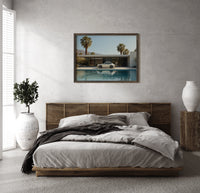 White 911 Desert Modern Pool House print in a wood frame above a bed with a woven cane headboard
