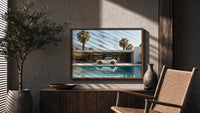 White 911 Desert Modern Pool House print in a walnut frame above a fluted sideboard and cane chair