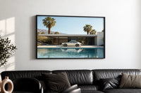 White 911 Desert Modern Pool House print in a black frame above a black leather sofa on a white wall