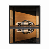 Framed White 911 Hangar Sunset Reflection print shown as a bold statement piece on a clean gallery wall