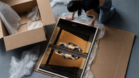 White 911 Hangar Sunset Reflection framed print being unpacked from protective bubble wrap and a box