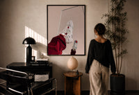 White Sneakers with Burgundy Trousers print in a black frame on a sunlit wall with a viewer