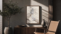 White Sneakers with Cream Trousers poster framed above a fluted sideboard beside a potted tree