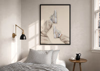 White Sneakers with Cream Trousers print in a black frame above a bed with striped linens