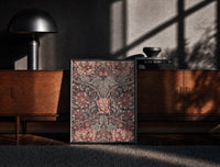 Black-framed Ornate floral honeysuckle pattern print on a moody console with designer coffee-table books