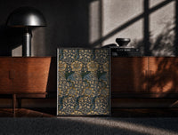 Black-framed Ornate floral vine pattern print on a moody console with designer coffee-table books