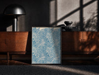Black-framed Floral marigold pattern with leaves print on a moody console with designer coffee-table books