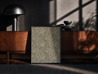 Black-framed Floral marigold vine pattern print on a moody console with designer coffee-table books