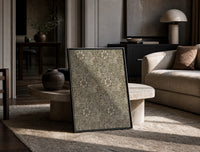 Floral marigold vine pattern print in a black frame leaning on a travertine table in a sunlit lounge