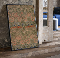 Floral bird damask textile pattern print in a black frame leaning beside a vintage door on parquet