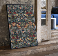 Birds and strawberries floral pattern print in a black frame leaning beside a vintage door on parquet