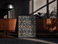 Black-framed Birds and strawberries floral pattern print on a moody console with designer coffee-table books