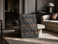Birds and strawberries floral pattern print in a black frame leaning on a travertine table in a sunlit lounge