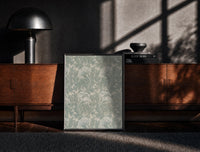 Black-framed Ornate floral tulip leaf pattern print on a moody console with designer coffee-table books