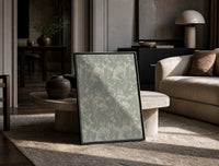 Ornate floral tulip leaf pattern print in a black frame leaning on a travertine table in a sunlit lounge