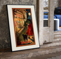 Witch with broom peering through window print in a black frame leaning beside a vintage door on parquet