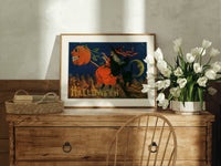Witch flying on broomstick with pumpkin print in an oak frame on a farmhouse dresser beside white tulips
