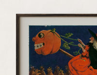 Close-up of the Witch flying on broomstick with pumpkin print's dark wood frame corner and archival matte paper