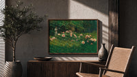 Woman reading among pink roses print in a wood frame above a fluted sideboard beside an olive tree