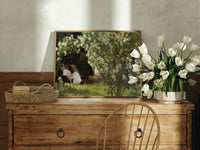 Woman reading in garden chair print in an oak frame on a farmhouse dresser beside white tulips