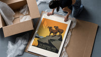 Two bighorn sheep on rocky cliff framed print being unpacked from protective bubble wrap and a box