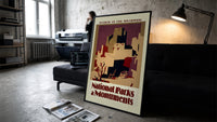Southwest pueblo cliff dwellings print in a slim black frame leaning on a dark sofa in a concrete print studio