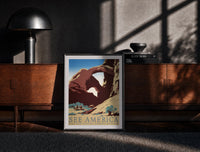 Black-framed Desert rock arch with riders print on a moody console with designer coffee-table books
