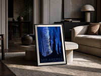 Cave stalactites with two tourists print in a black frame leaning on a travertine table in a sunlit lounge