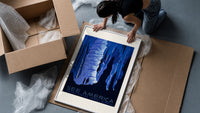 Cave stalactites with two tourists framed print being unpacked from protective bubble wrap and a box